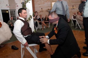 blindfolded groom groping for the garter on a groomsmen at the appel inn altamont ny