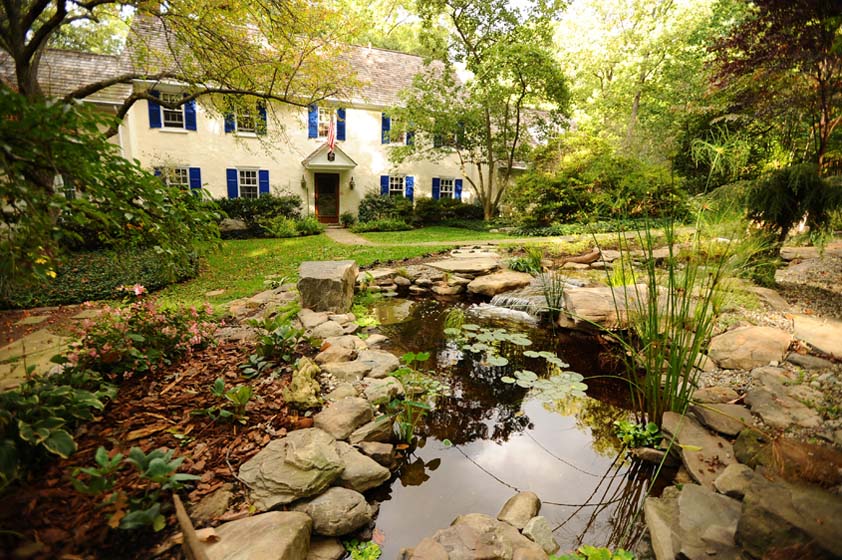 photo of a beautiful old colonial mansion with a goldfish pond